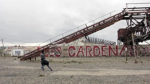 Two Boys Throwing Rocks at Coal Conveyor, Rio Gallegos, Argentina Stock Footage 312004783