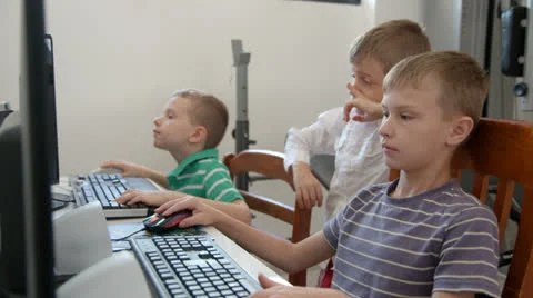 Two boys using a computer as one boy looks on Video stock 22570596