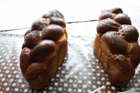 Two braided festive breads topped with poppy seeds rest on a table, creating  Stock Photos
