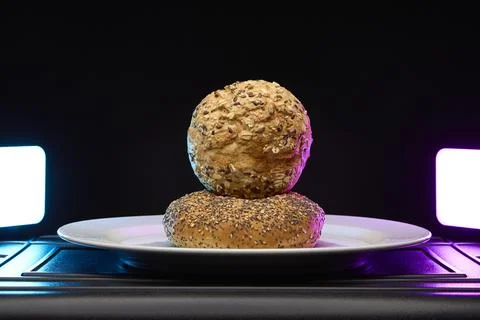 Two bread rolls stacked with artistic light and dark background 写真素材
