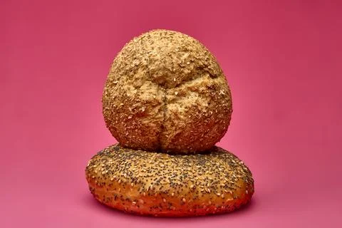Two bread rolls stacked on a pink surface in studio light Stock Photos