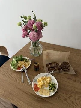 Two breakfast plates with eggs, cheese, avocado, and vegetables on a wooden Foto stock