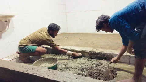 Two bricklayers handle cement work during shop upgrade Stock Footage 312724411
