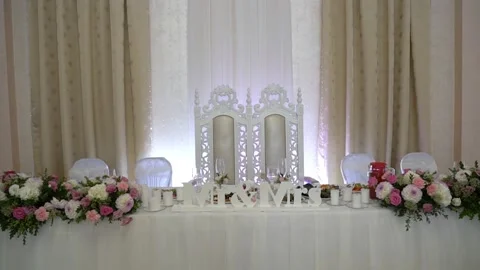 Two brides chairs at the wedding table. the table is decorated with flowers. 'Mr Video stock 130975799