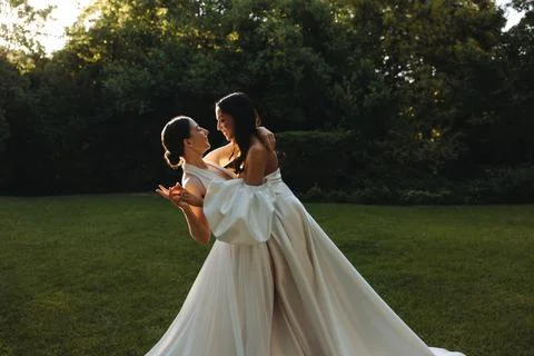Two brides dancing together in a serene outdoor garden setting Foto stock