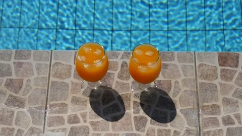 Two bright beautiful orange yellow cocktails juice with ice stand close-up Stock Footage 138767357