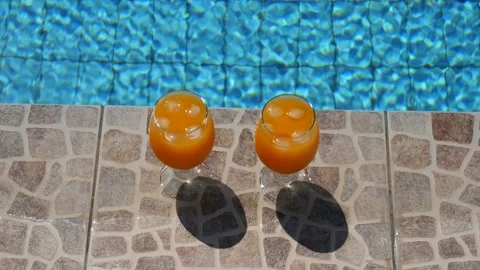 Two bright beautiful orange yellow cocktails juice with ice stand close-up Stock Footage 138769129
