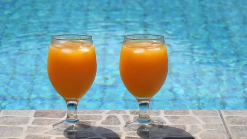 Two bright beautiful orange yellow cocktails juice with ice stand close-up Stock Footage 138769722