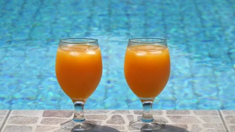 Two bright beautiful orange yellow cocktails juice with ice stand close-up Stock Footage 138770047