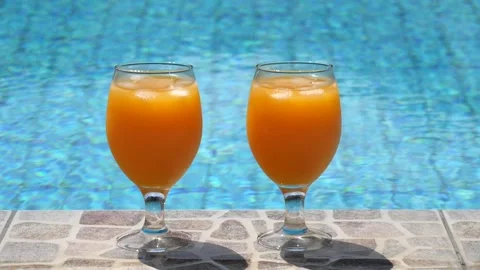 Two bright beautiful orange yellow cocktails juice with ice stand close-up Stock Footage 138770136