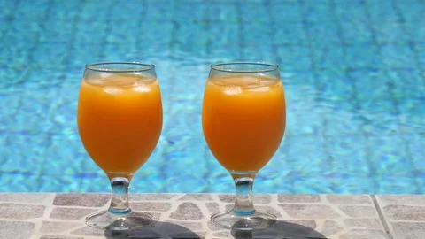 Two bright beautiful orange yellow cocktails juice with ice stand close-up Stock Footage 138770438