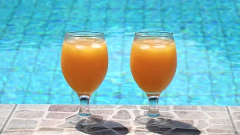 Two bright beautiful orange yellow cocktails juice with ice stand close-up Stock Footage 138770662