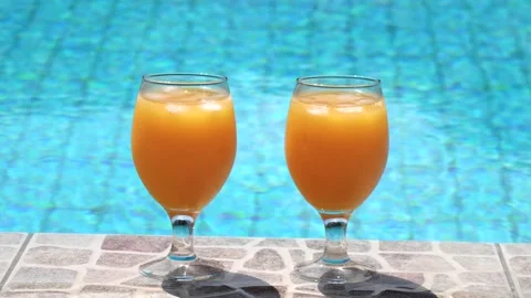 Two bright beautiful orange yellow cocktails juice with ice stand close-up Stock Footage 138770700