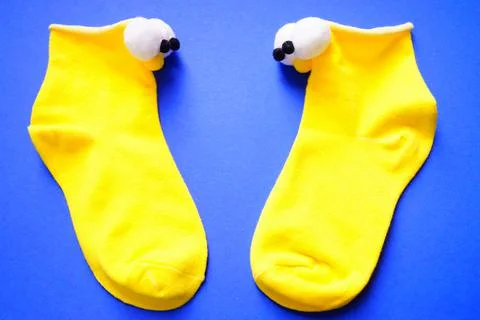 Two bright blue socks with funny eyes on a blue background. Puppet theatre. View Stock-Fotos