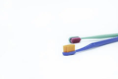 Two bright colored toothbrushes on a white background on the right close-up Foto stock