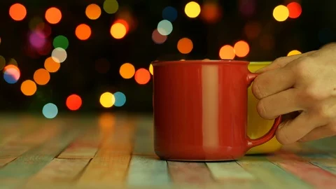Two bright mugs of hot drink with steam on dark backgroud with colorful lights Stock Footage 123084013