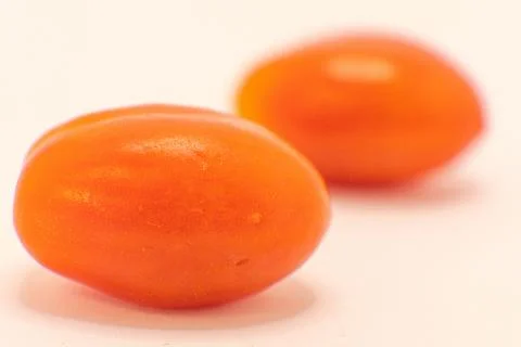 Two bright orange cherry tomatoes, fresh and ready for a healthy snack or to  Stock Photos