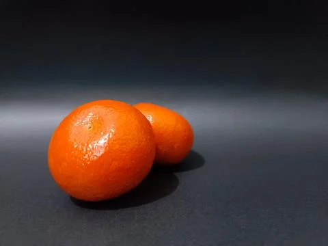 Two bright orange oranges with a slightly shiny orange peel texture. Fotos de archivo