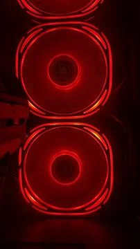 Two bright red glowing cooling fans operating inside a gaming computer Stock Photos
