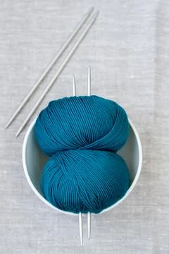 Two bright turquoise skeins of thread and needles for knitting Stock Photos