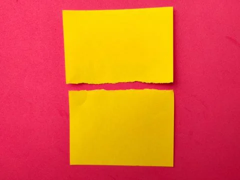 Two bright yellow rectangular paper scraps with uneven, torn edges are cent.. Stockfoto's