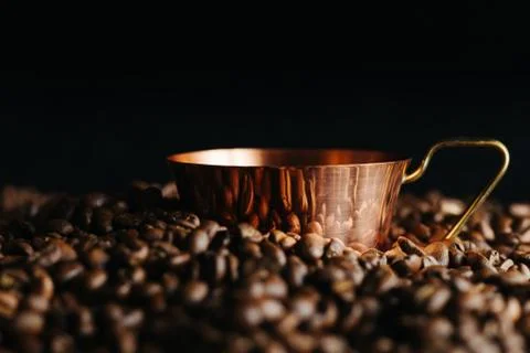 Two bronze cup full of coffee on the grains pile. Italian traditional morning Foto stock