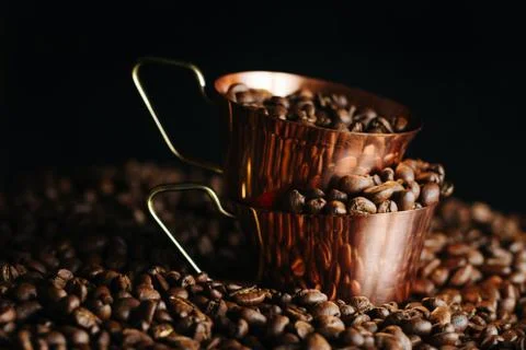 Two bronze cup full of coffee on the grains pile. Italian traditional morning 스톡 사진