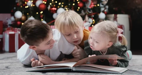 Two brothers and sister are playing near Christmas tree Video stock 213944738