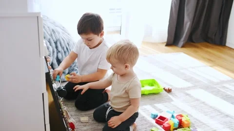 Two brothers are playing with constructor with bunch of objects at home. Stock Footage 297978256