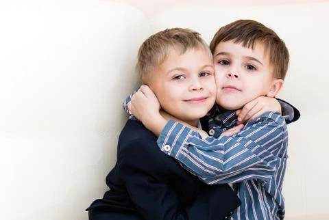 Two brothers cuddling on the couch Stock Photos