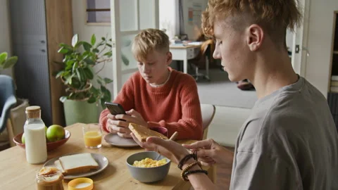 Two Brothers Eating Breakfast Sitting at Kitchen Table Stock Footage 318553388