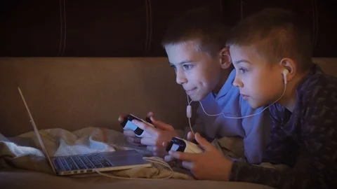 Two brothers or friends smiling and having fun playing a game with controllers Stock Footage 101028693