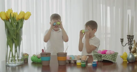 Two brothers play with colored eggs. after painting the eggs for Easter, put Stock Footage 172502310