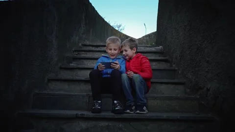 Two brothers play computer games. Friends play mobile games on smartphones. Stock Footage 138170533