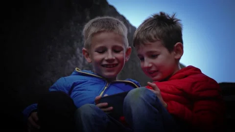 Two brothers play computer games. Watching a video outside. Stock Footage 147431288