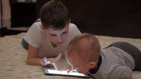 Two Brothers Playing With Digital Tablet On Sofa. Video stock 70065636