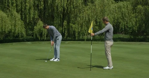 Two brothers playing golf, one missis the putt the other is happy! Video stock 101644467