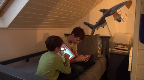 Two brothers playing with smart phone and tablet computer, indoors Stock Footage 33797164