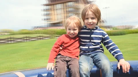 Two brothers turn into a manual carousel on a playground Stock-Footage 130658906