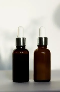Two brown dropper bottles or glass cosmetic jars without labels close-up Stock Photos