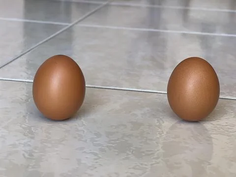 Two Brown Eggs Balancing Upright On Tiled Floor For Lichun Festival Foto stock