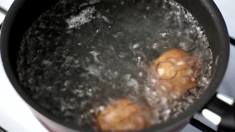 Two brown eggs boiled in a pot of boiling water Stock Footage 179921460