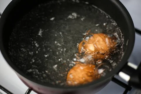 Two brown eggs in a pot of boiling water Stock Photos