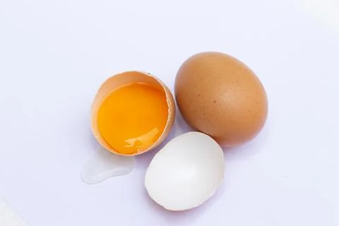 Two brown eggs There was one egg broken in half, with a yolk inside the eggsh Stock Photos