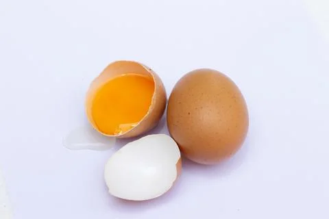 Two brown eggs There was one egg broken in half, with a yolk inside the eggsh Stock Photos