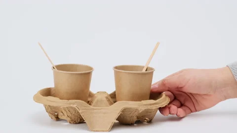 Two brown paper cups stand on a cardboard stand on a white background, zero wast Stock Footage 147548650