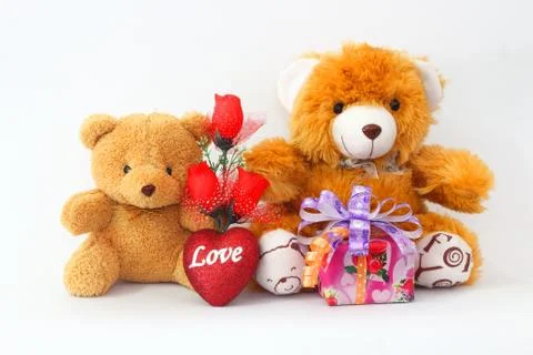 Two brown teddy bear with a red rose and a gift box on a white background. Foto stock