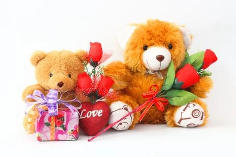 Two brown teddy bear with a red rose and a gift box on a white background. Stock-Fotos