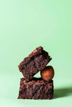 Two brownies stack and a hazelnut. Pile of chocolate brownies Stock Photos