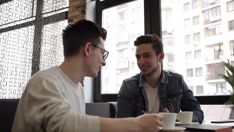 Two buddies sitting in the cafe and chatting with each other Stock Footage 74855421